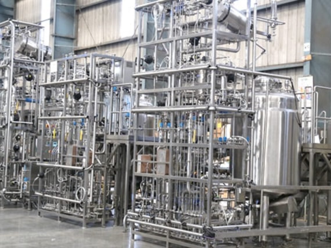 A woman standing in front of a machine in a factory a woman standing in front of a machine in a factory