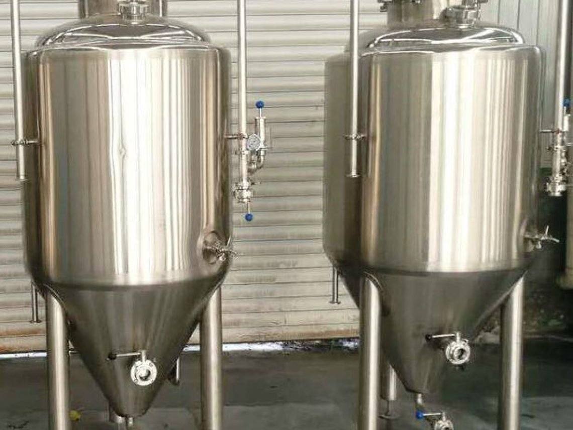 Two stainless steel tanks sitting next to each other Two stainless steel tanks sitting next to each other.