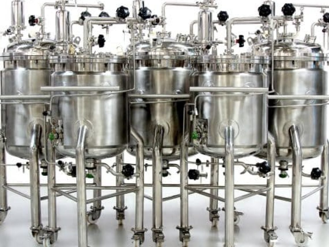 a group of stainless steel tanks sitting next to each other