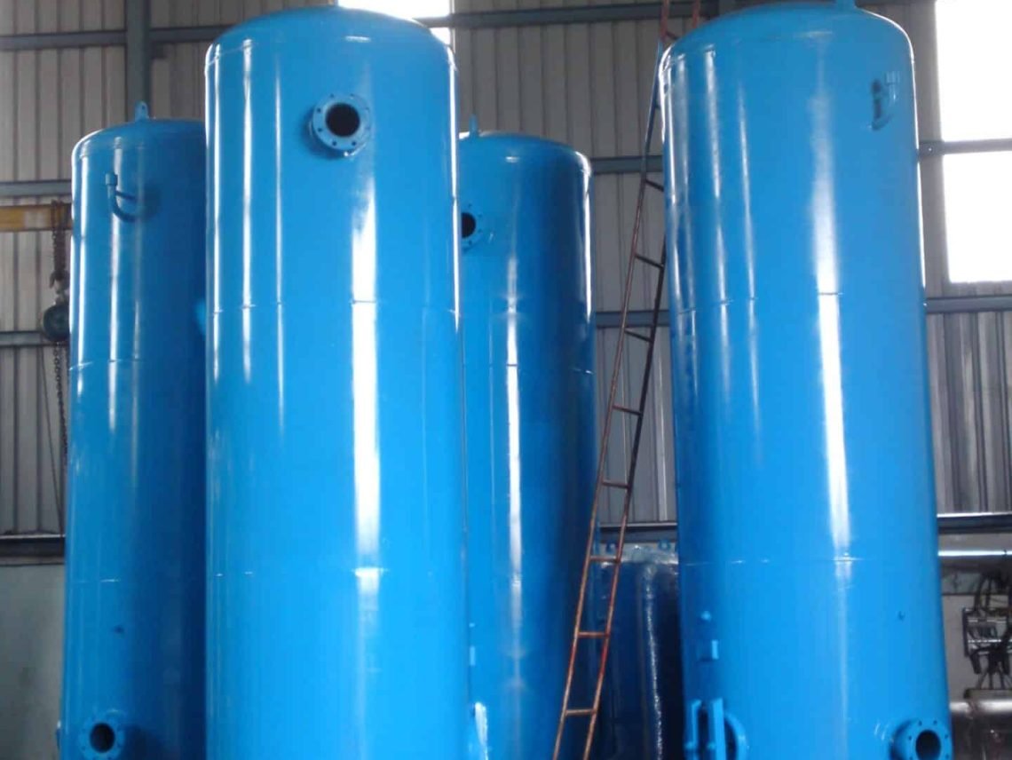 a group of large blue tanks sitting inside of a building large blue tanks