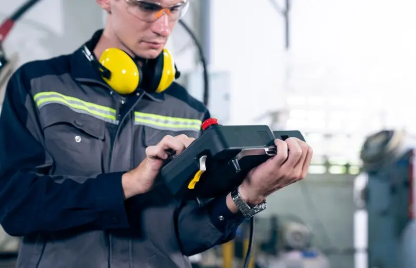 Technician performing ultrasonic testing on weld to detect subsurface defects