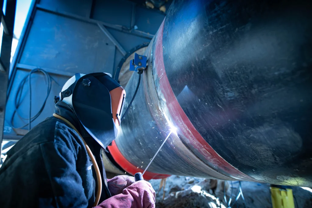 Technician performing magnetic particle testing on a welded pressure vessel.