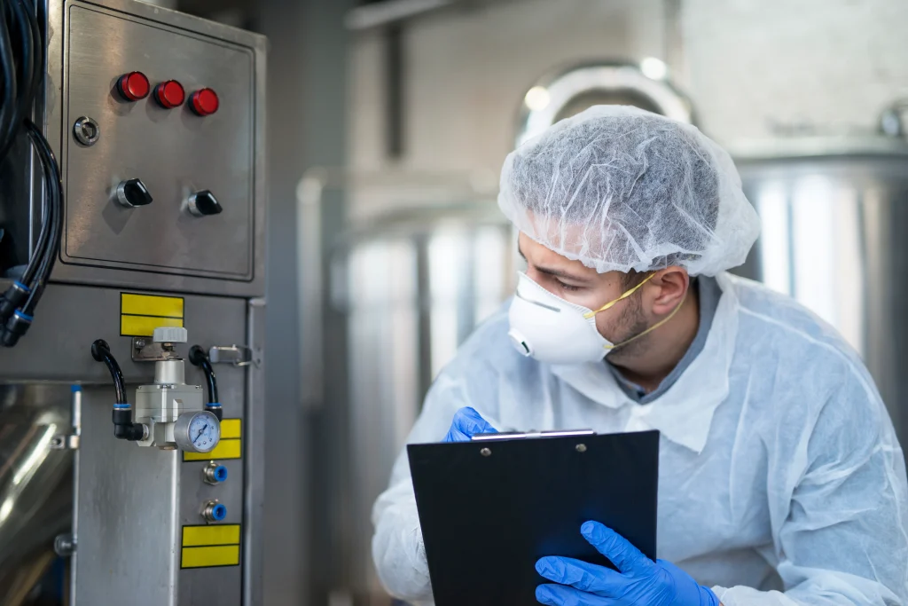 Technician inspecting pressure vessel with hazardous material safety gear