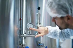 Quality inspector measuring pressure vessel dimensions with precision laser equipment