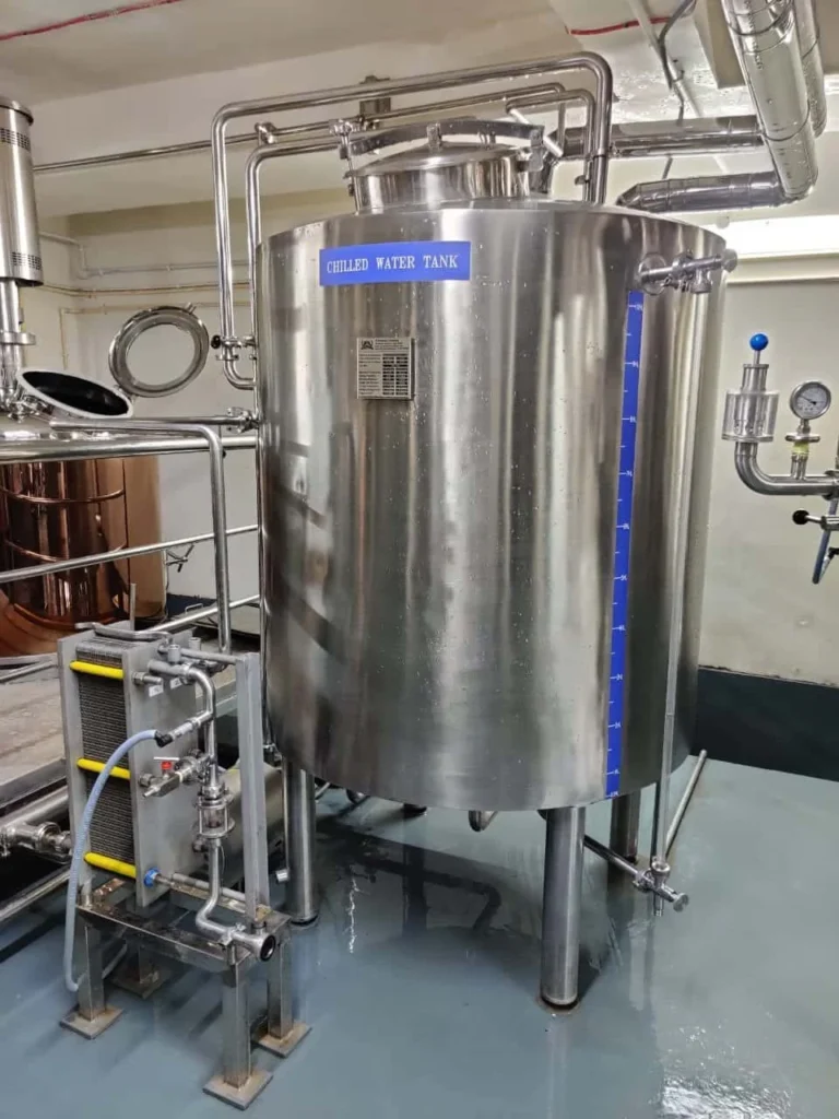 A large stainless steel tank sitting inside of a building.
