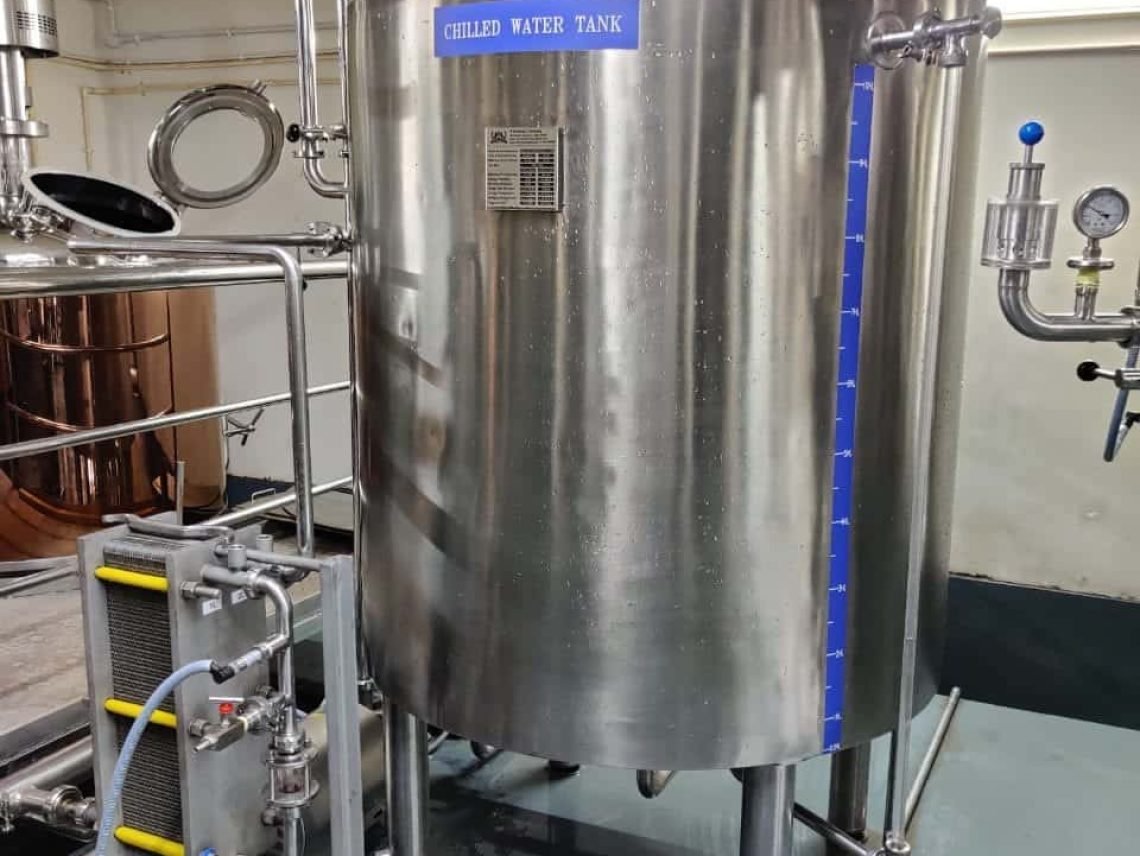 A large stainless steel tank sitting inside of a building.