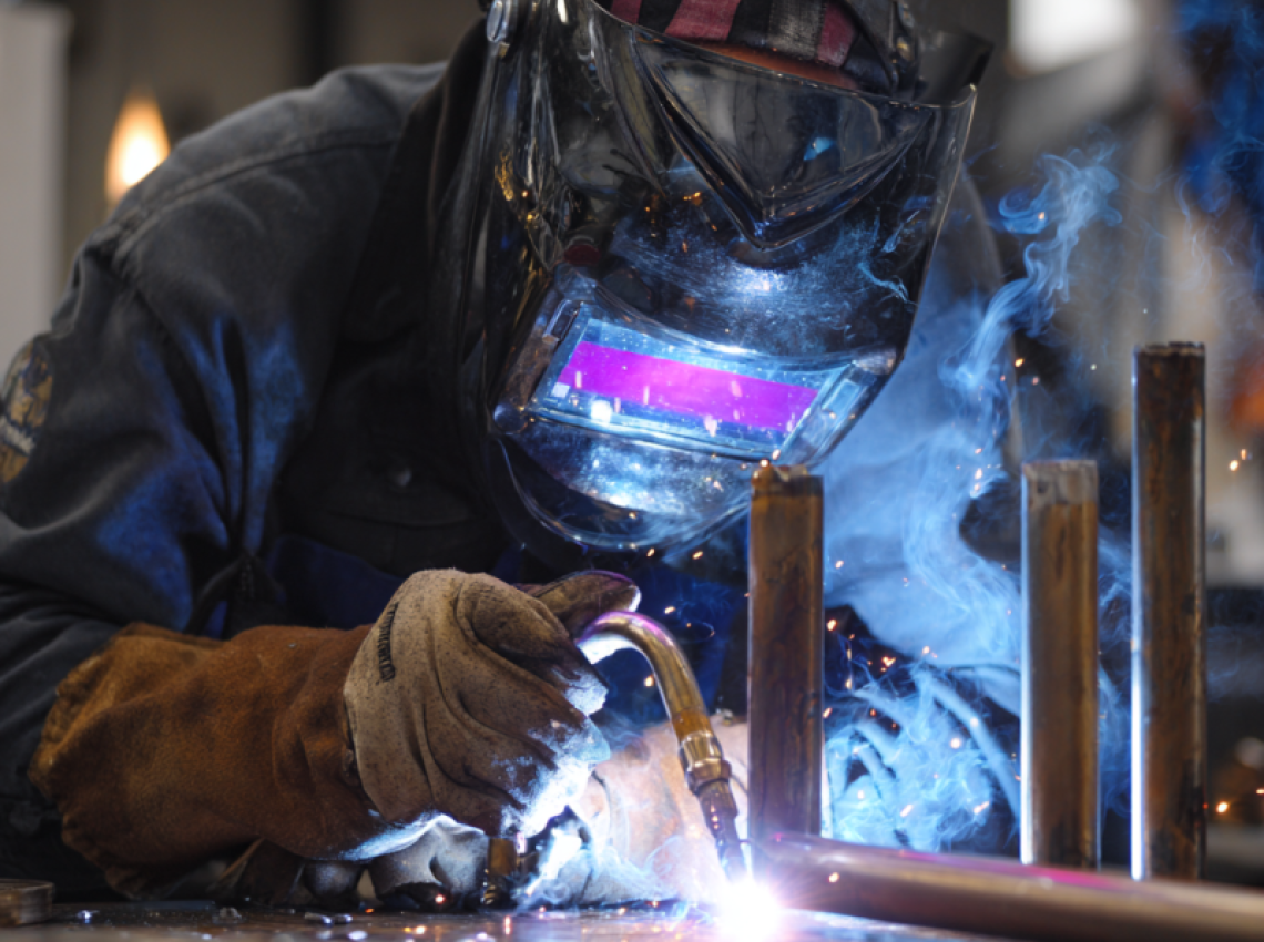 Welder practicing gtaw welding certification test on metal plate