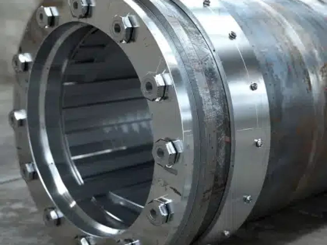 Close-up of a large industrial pipe fitting with metal flanges and bolts, commonly used in pressure vessel manufacturing.